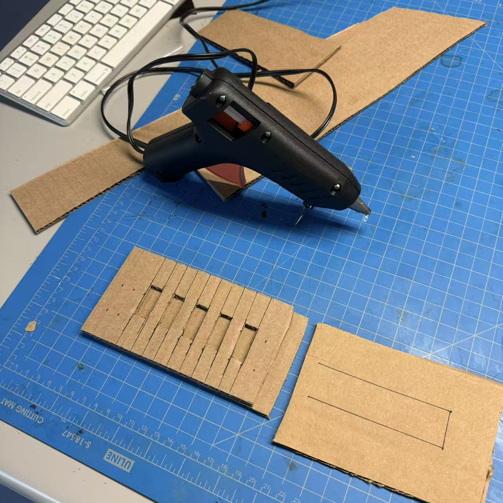 After cropping the parts that we need for our phone stand, we used glue gun to stick all of the parts together that can allow us to make the final phone stand. It wasn't stable at first because the phone was to heavy, therefore we added more cardboard to make the phone stand more stable than before.